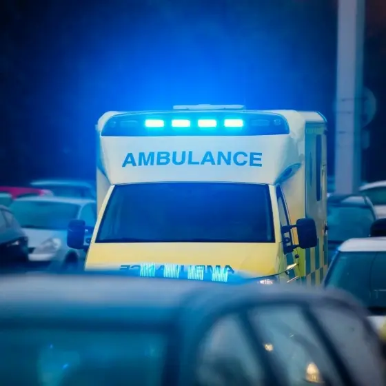 Ambulance driving through traffic with the emergency lights on