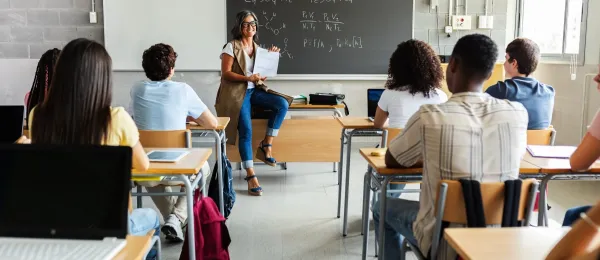 Classroom with teacher showing students a paper