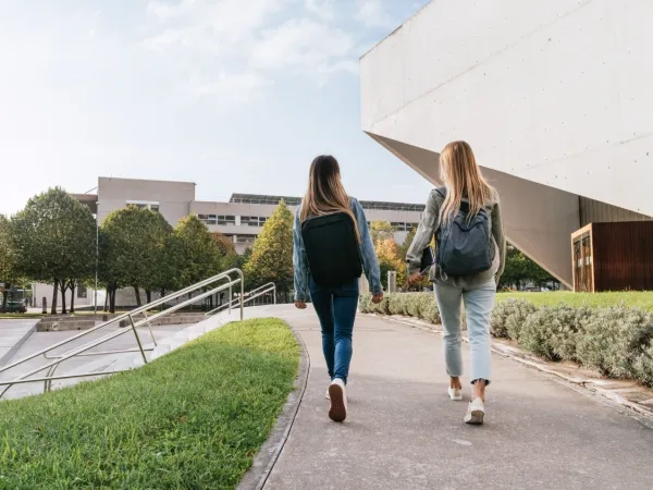 Campus area with two students walking on a path