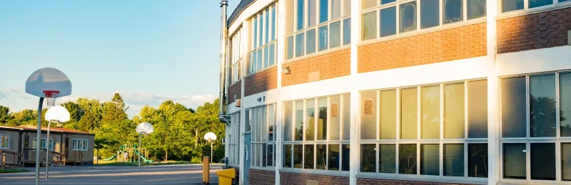 School building with a basketball court outside