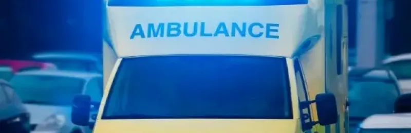 Ambulance driving through traffic with the emergency lights on