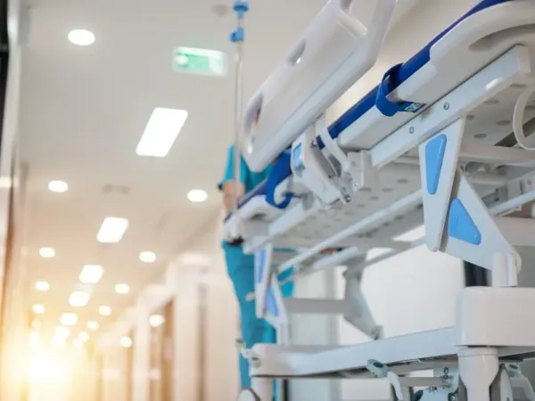 Hospital bed being rolled down a hall