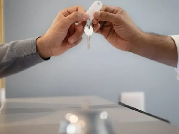 A picture of a key being passed across a reception desk