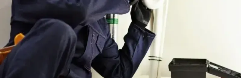 Picture of a maintence worker fixing a sink