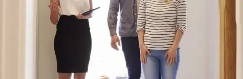 Picture of a couple being shown around a house